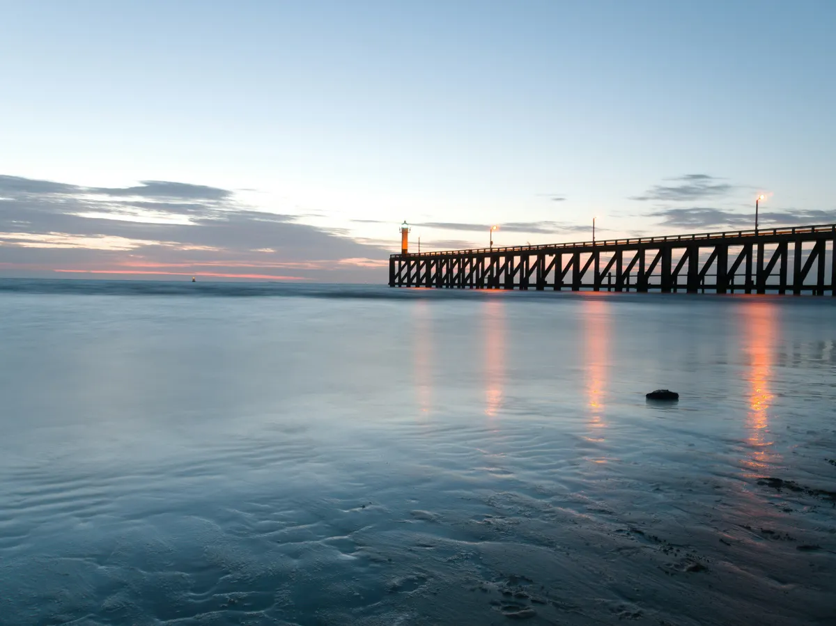 Blankenberge pier at dusk stretching into the calm North Sea, moody atmospheric view of the Belgian coast